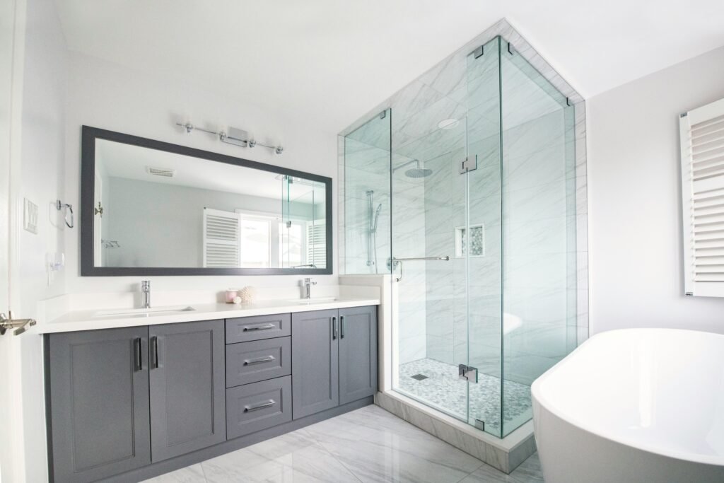 Bright modern bathroom remodel with glass shower, double vanity and freestanding tub